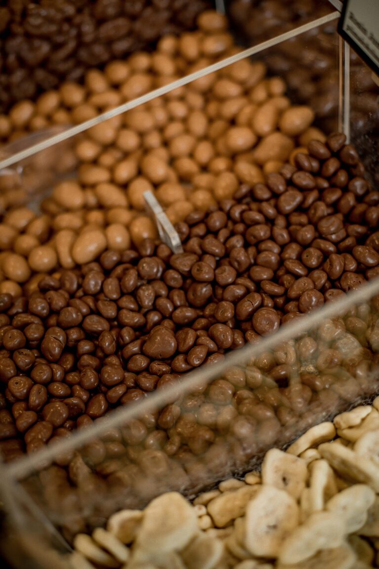 Delicious assortment of chocolate coated snacks with fruits and nuts in a retail display.